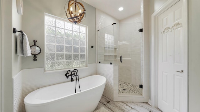 700 N Indigo Ter, Saint Johns, FL 32259 - bathroom featuring a freestanding bath, a stall shower, wainscoting, a chandelier, and tile walls