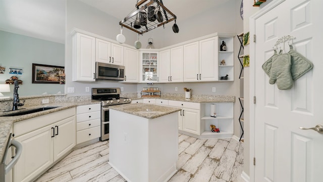 700 N Indigo Ter, Saint Johns, FL 32259 - kitchen featuring appliances with stainless steel finishes, open shelves, a sink, white cabinetry, and glass insert cabinets