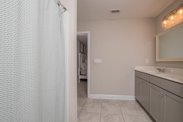 bathroom with vanity, tile patterned floors, and a textured ceiling