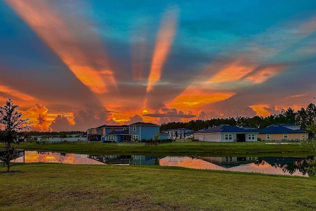 surrounding community featuring a water view and a lawn