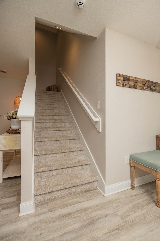 stairway featuring wood-type flooring