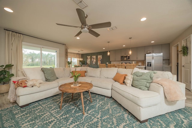 living room featuring hardwood / wood-style flooring and ceiling fan