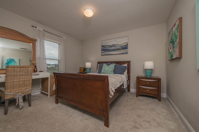 bedroom featuring light carpet and a textured ceiling