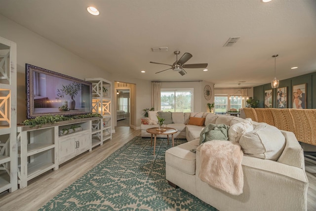 living room with ceiling fan and light wood-type flooring