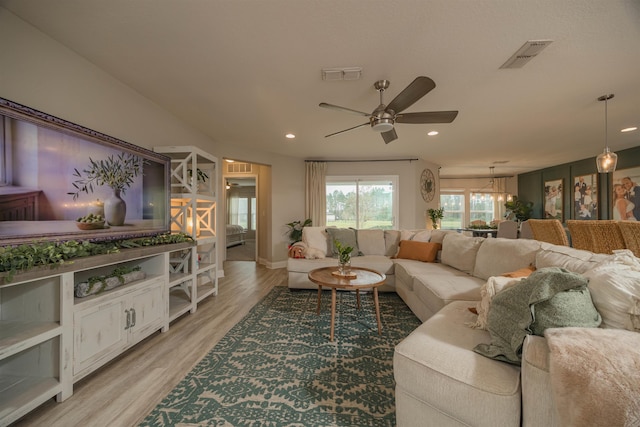 living room featuring light hardwood / wood-style floors and ceiling fan