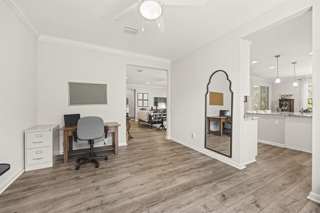 home office with visible vents, ornamental molding, and wood finished floors