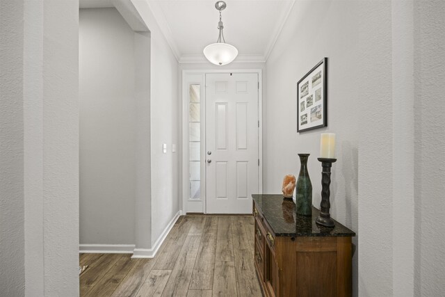 entryway with crown molding, baseboards, and hardwood / wood-style floors