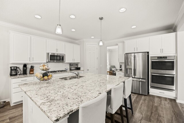 kitchen with a sink, crown molding, stainless steel appliances, and dark wood-style flooring