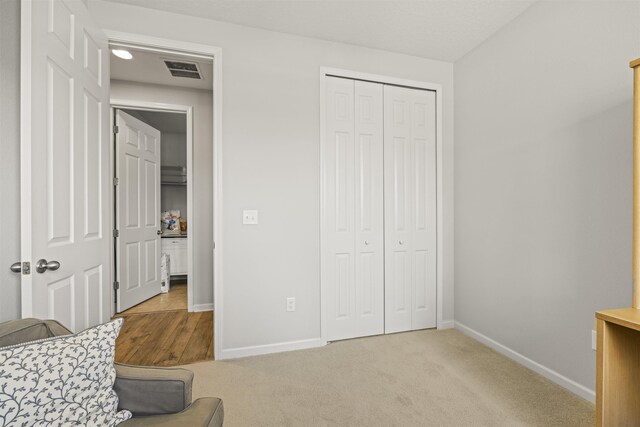 bedroom featuring visible vents, carpet, baseboards, and a closet
