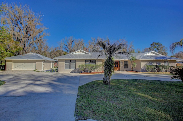 single story home with a garage and a front lawn