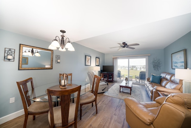 dining area with wood-type flooring and ceiling fan with notable chandelier