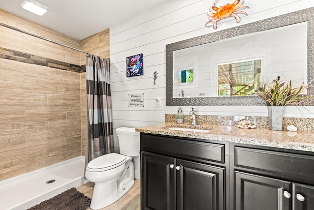 bathroom with toilet, vanity, wooden walls, and curtained shower