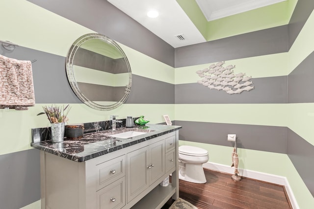 bathroom with ornamental molding, vanity, toilet, and hardwood / wood-style floors