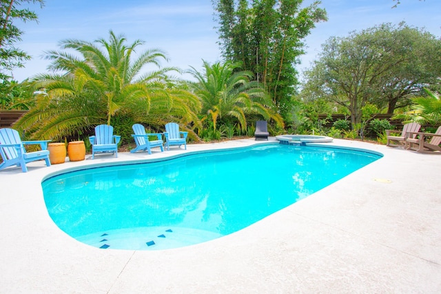 view of pool featuring a patio area and an in ground hot tub