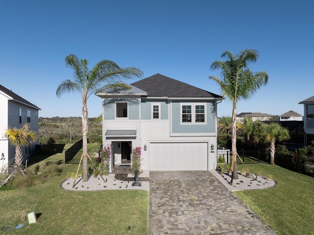 view of front of home with a front lawn, decorative driveway, fence, and a garage