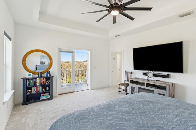 carpeted bedroom with access to exterior, visible vents, a raised ceiling, and baseboards