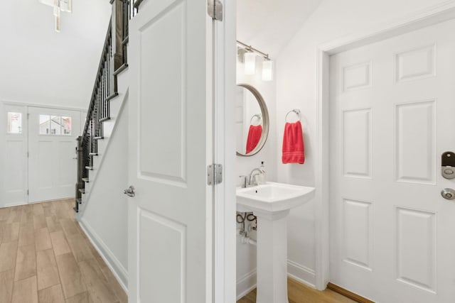 bathroom featuring wood finished floors, baseboards, and a sink