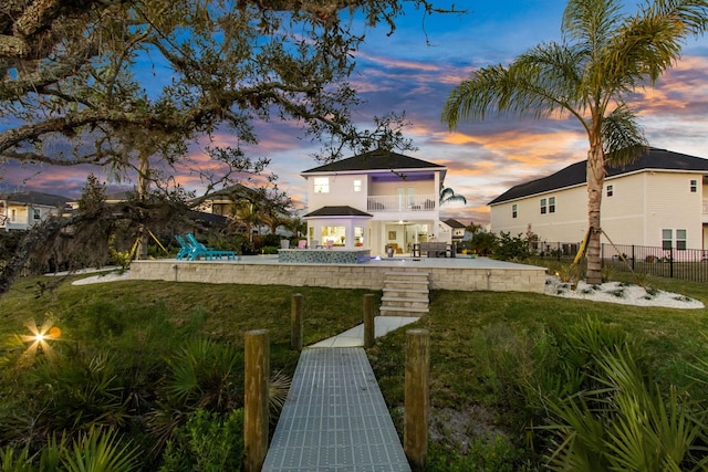 back of house with a lawn, a patio, fence, a fenced in pool, and a balcony