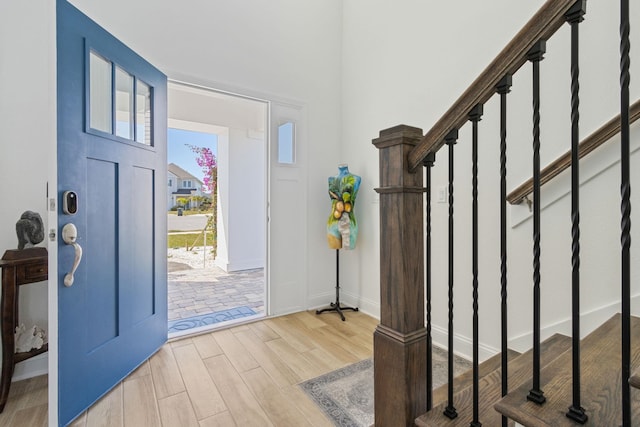 entrance foyer with stairs, wood finished floors, and baseboards