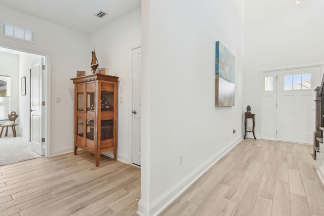 corridor with visible vents, plenty of natural light, and light wood-style flooring