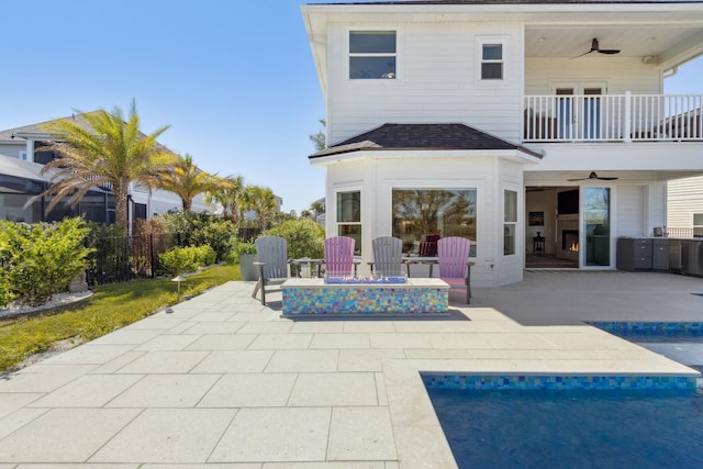 back of property with ceiling fan, a patio, a balcony, and a fenced in pool