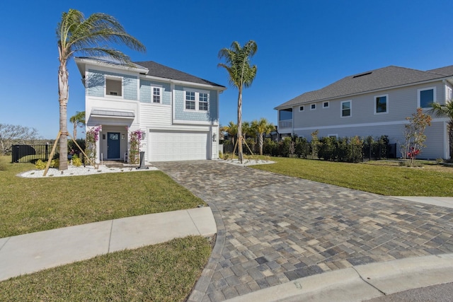 view of front facade featuring decorative driveway, an attached garage, a front yard, and fence