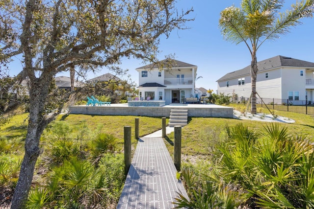 back of property featuring a pool, fence, a lawn, a balcony, and a patio