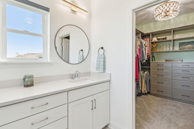 bathroom with a spacious closet and vanity