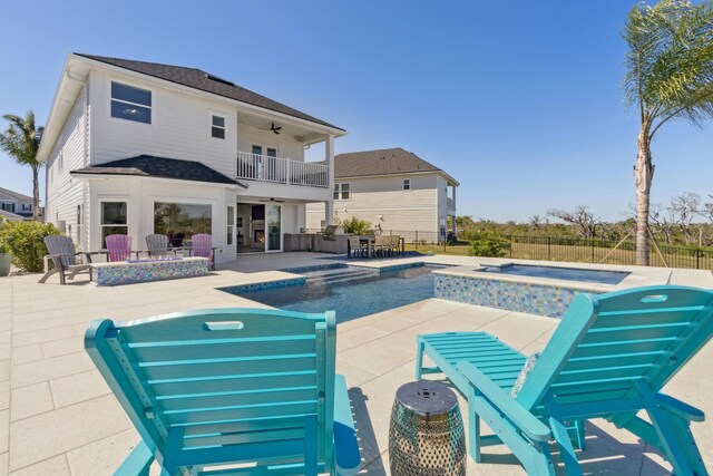 view of swimming pool featuring a fenced in pool, ceiling fan, fence, an outdoor fire pit, and an in ground hot tub