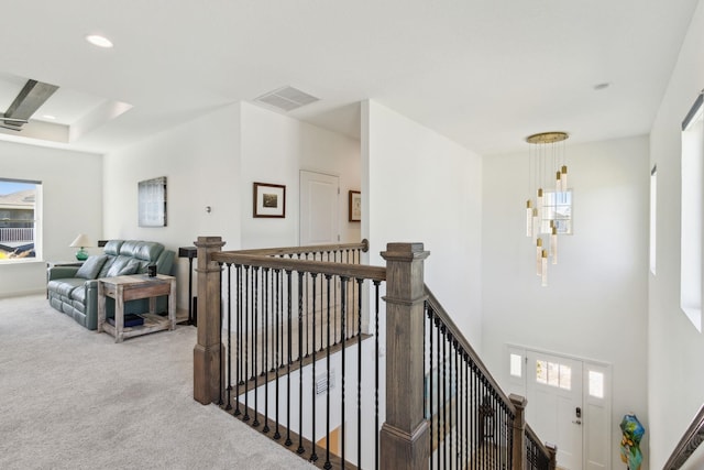 hallway featuring an upstairs landing, carpet flooring, plenty of natural light, and visible vents