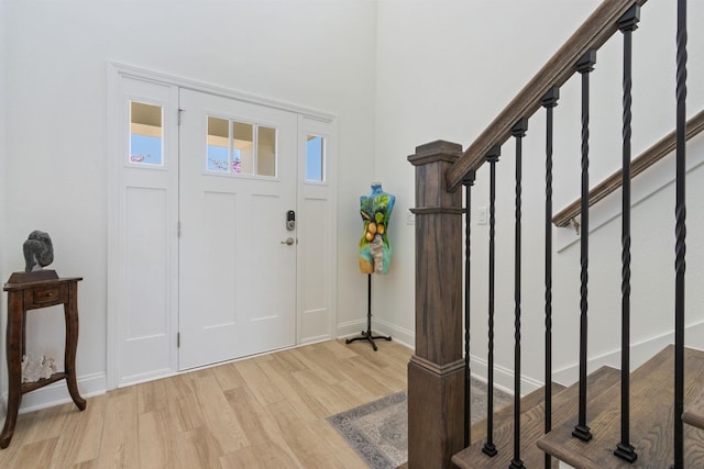 entryway featuring stairway, baseboards, and light wood finished floors