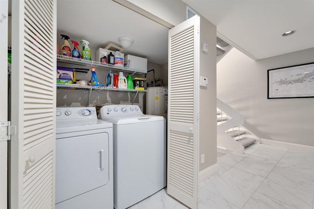 laundry room with water heater and washing machine and clothes dryer