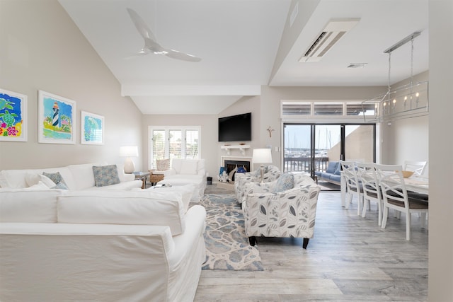 living room with ceiling fan, light wood-type flooring, and lofted ceiling