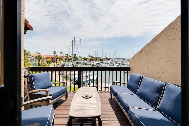 wooden terrace featuring an outdoor hangout area and a water view