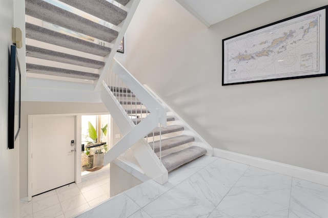 stairway with beamed ceiling