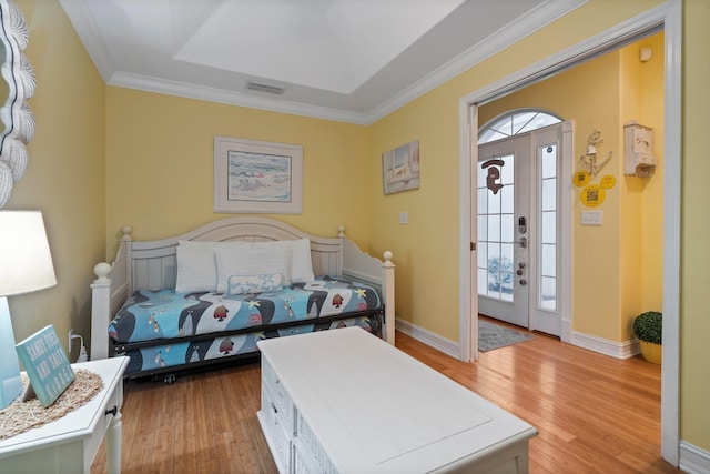 bedroom featuring access to outside, ornamental molding, a raised ceiling, and light wood-type flooring