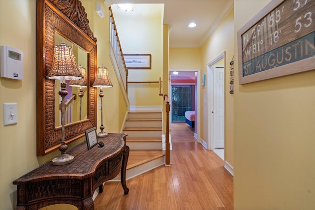 hallway with ornamental molding and light wood-type flooring