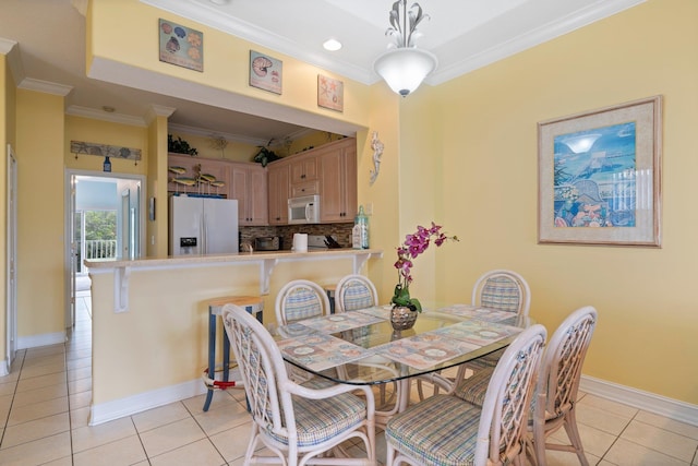 dining room featuring light tile patterned flooring and crown molding