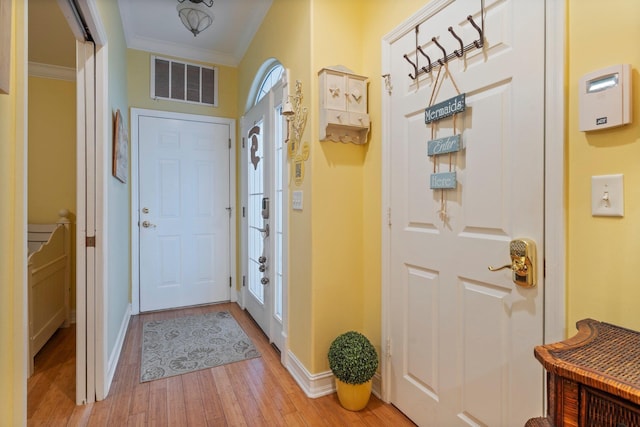 entryway featuring crown molding and light hardwood / wood-style flooring