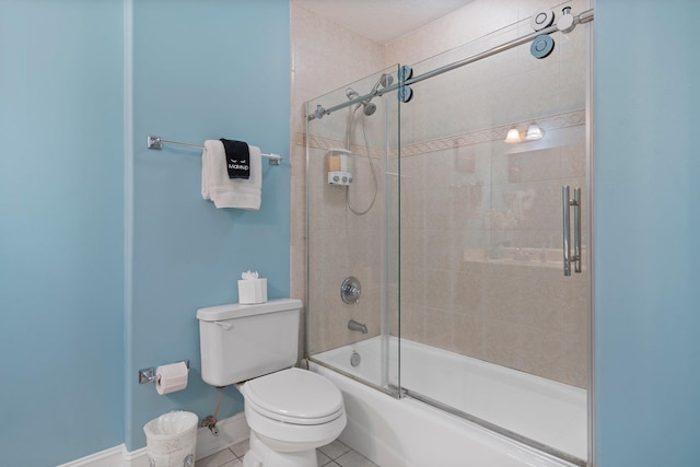 bathroom featuring toilet, bath / shower combo with glass door, and tile patterned flooring