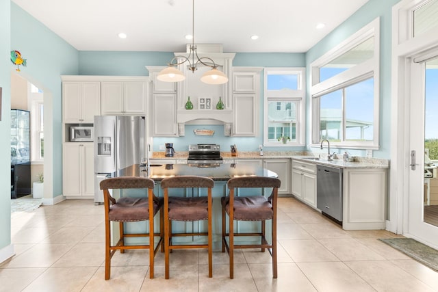 kitchen featuring pendant lighting, sink, white cabinets, and appliances with stainless steel finishes