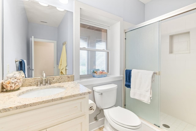 bathroom with walk in shower, vanity, and toilet