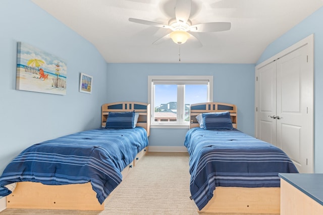 bedroom featuring vaulted ceiling, light carpet, ceiling fan, and a closet