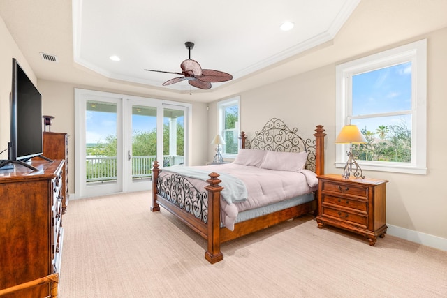 carpeted bedroom featuring ceiling fan, ornamental molding, a tray ceiling, and access to outside