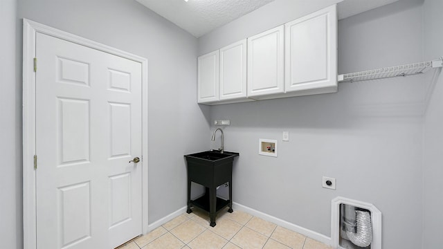 washroom featuring cabinets, hookup for a washing machine, electric dryer hookup, light tile patterned floors, and a textured ceiling