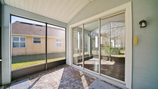 unfurnished sunroom featuring vaulted ceiling