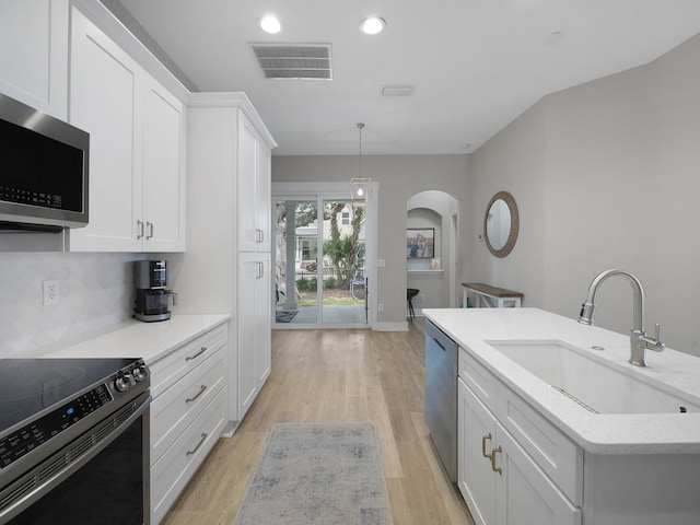 847 Tides End Dr, Saint Augustine, FL 32080 - kitchen featuring white cabinetry, a sink, visible vents, stainless steel appliances, and arched walkways