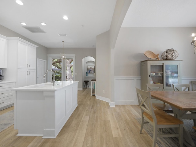 847 Tides End Dr, Saint Augustine, FL 32080 - kitchen featuring a wainscoted wall, arched walkways, visible vents, and light wood-style flooring