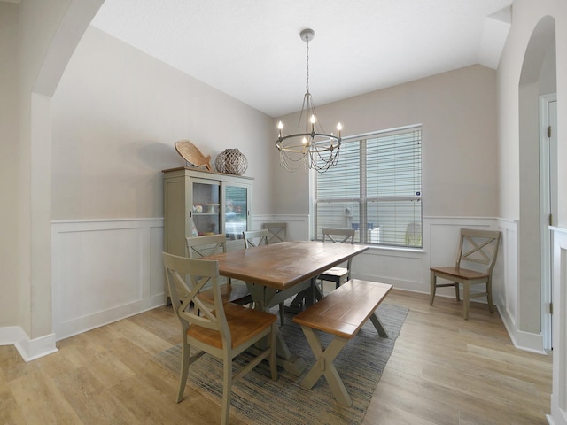 847 Tides End Dr, Saint Augustine, FL 32080 - dining space featuring wainscoting, arched walkways, a notable chandelier, and light wood-style flooring