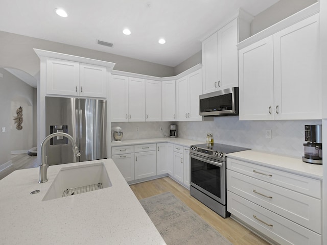 847 Tides End Dr, Saint Augustine, FL 32080 - kitchen with light wood-style flooring, stainless steel appliances, white cabinets, a sink, and visible vents